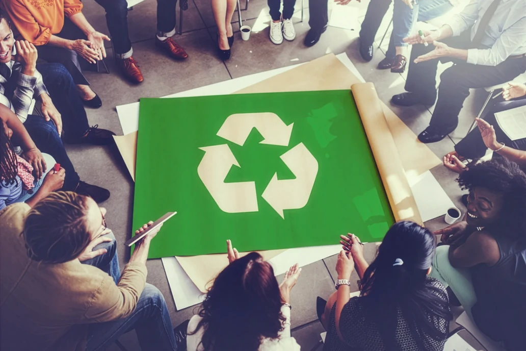 Colegi de munca in jurul simbolului de reciclare