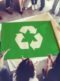 Colegi de munca in jurul simbolului de reciclare